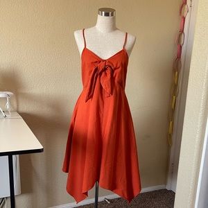 Burnt orange front bow tie dress with pockets; handkerchief hem; lightly worn